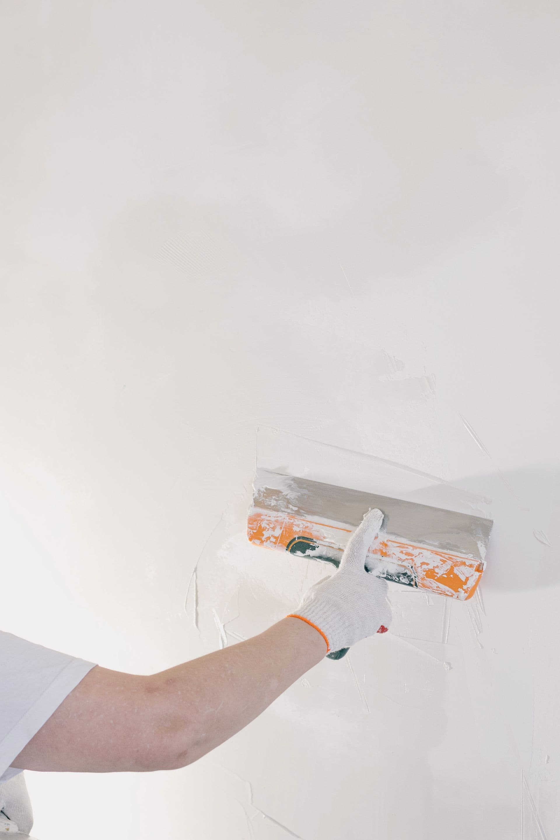 Plasterer skimming a wall with a trowel